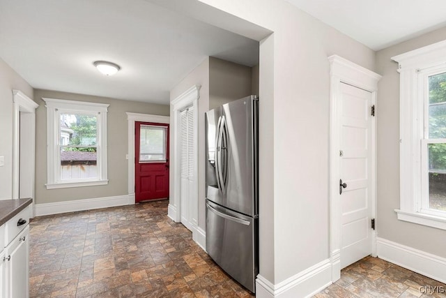 264 S 5th St, Fulton, NY 13069 - kitchen with stainless steel fridge with ice dispenser, stone finish floors, baseboards, and dark countertops