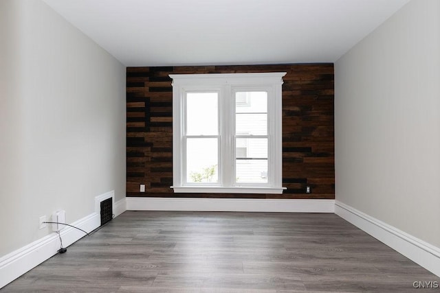 264 S 5th St, Fulton, NY 13069 - unfurnished room featuring baseboards, an accent wall, and wood finished floors