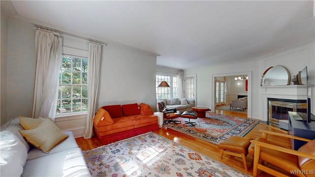 80 Lake St, Urbana, NY 14840 - living room featuring wood finished floors, healthy amount of natural light, crown molding, a glass covered fireplace, and baseboards