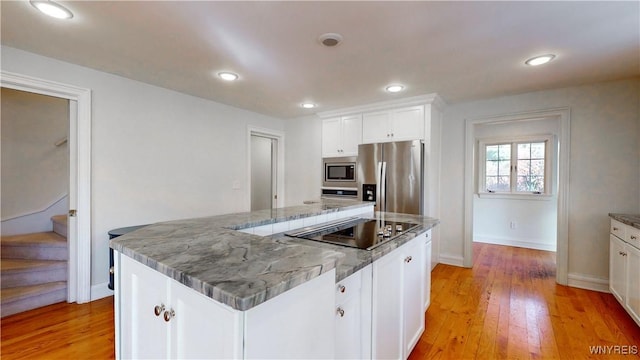 80 Lake St, Urbana, NY 14840 - kitchen with appliances with stainless steel finishes, white cabinets, light wood-type flooring, a kitchen island, and baseboards