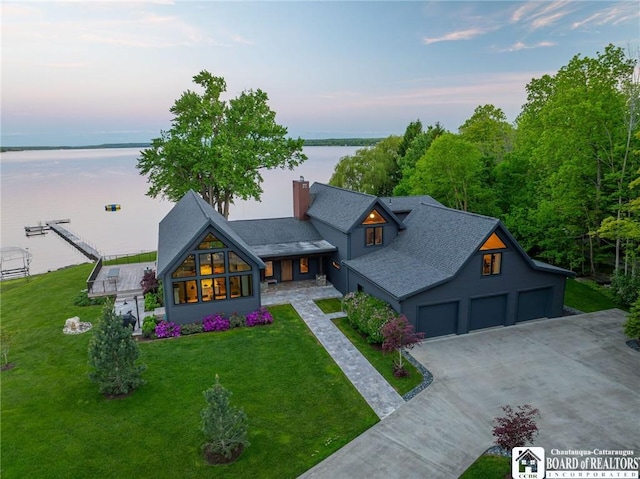 6007 Tinkertown Dr, Chautauqua, NY 14728 - view of front of home with a water view, concrete driveway, a chimney, a lawn, and a garage
