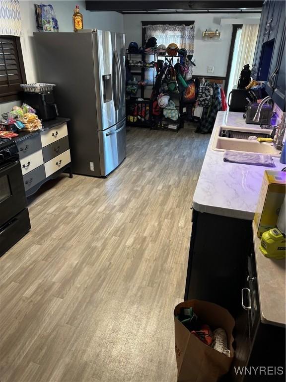 125 Spaulding St, Buffalo, NY 14220 - kitchen with stove, stainless steel fridge with ice dispenser, a sink, light wood-type flooring, and light countertops