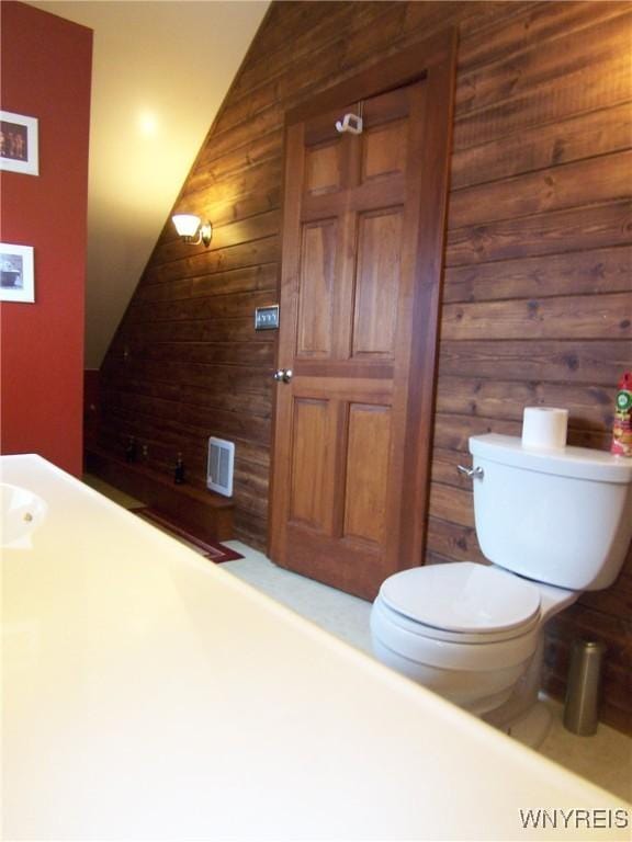 8330 Greiner Rd, Clarence, NY 14221 - bathroom featuring wooden walls, toilet, and lofted ceiling