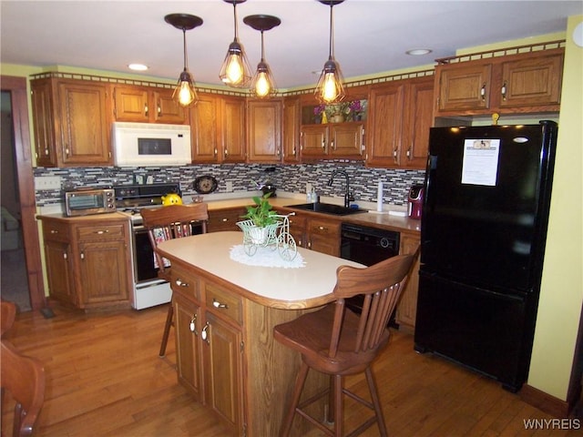 8330 Greiner Rd, Clarence, NY 14221 - kitchen with freestanding refrigerator, white microwave, a sink, stove, and wood finished floors