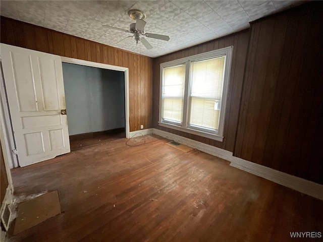 500 Massachusetts Ave, Buffalo, NY 14213 - unfurnished bedroom featuring baseboards, wood finished floors, a closet, wood walls, and a ceiling fan