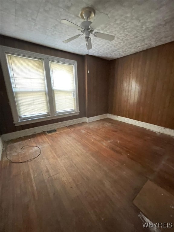 500 Massachusetts Ave, Buffalo, NY 14213 - empty room featuring a ceiling fan, wood finished floors, wooden walls, and baseboards