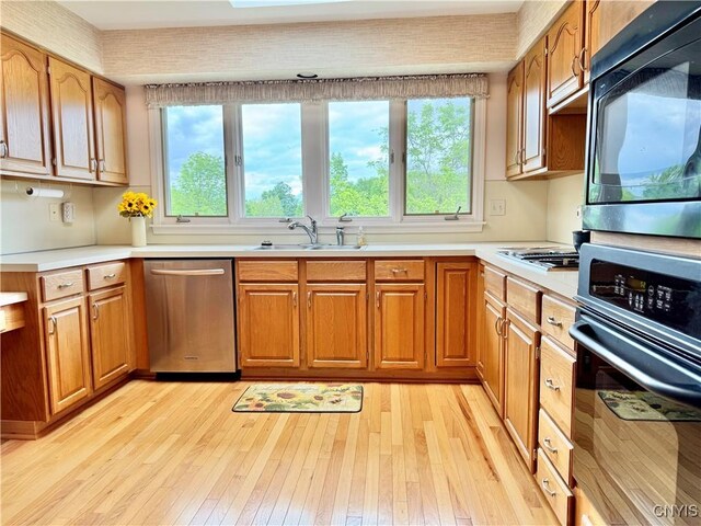 111 Spyglass Ln, Manlius, NY 13066 - kitchen featuring black appliances, a sink, light countertops, light wood-style flooring, and brown cabinets