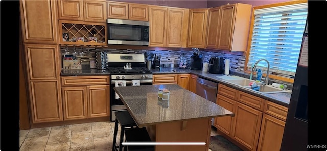 251 Minnesota Ave, Buffalo, NY 14215 - kitchen featuring appliances with stainless steel finishes, a sink, decorative backsplash, a kitchen island, and light stone finish flooring