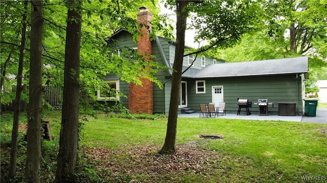 7066 E Ln, Boston, NY 14057 - back of house with a chimney, a patio area, and a lawn