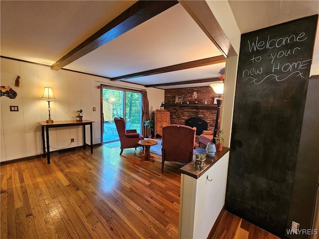 7066 E Ln, Boston, NY 14057 - living area featuring beamed ceiling, wood-type flooring, a brick fireplace, and baseboards
