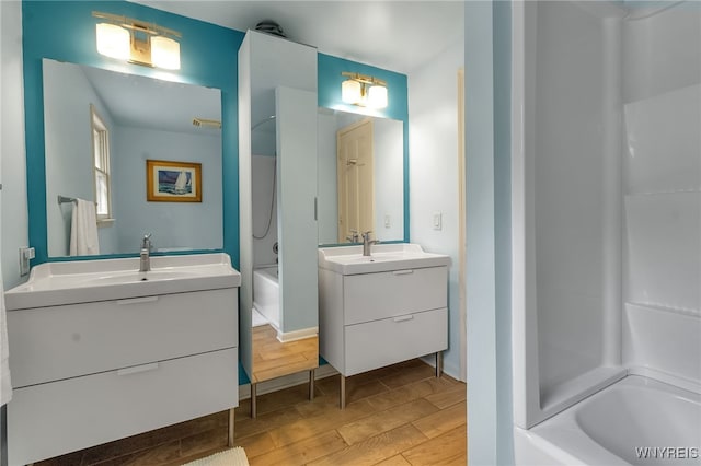 7066 E Ln, Boston, NY 14057 - bathroom featuring tub / shower combination, two vanities, and wood finished floors