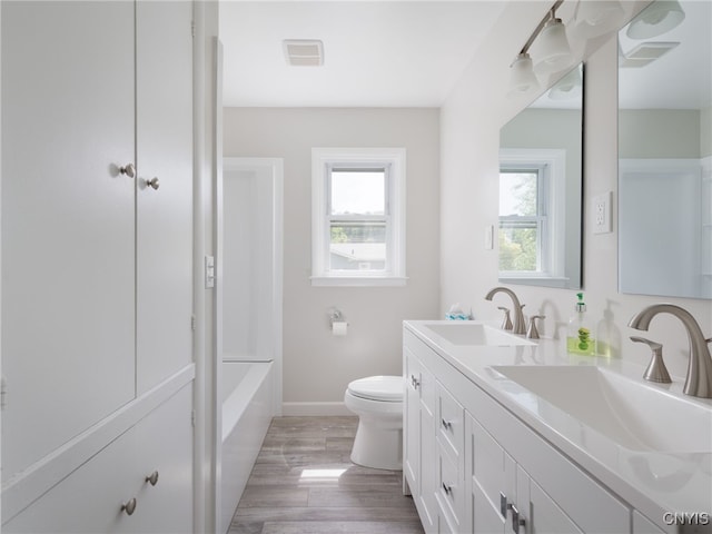 1120 Temple St, Watertown-City, NY 13601 - bathroom with double vanity, toilet, wood finished floors, baseboards, and shower / bath combination