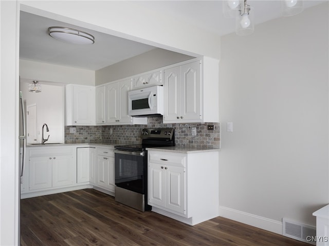 1120 Temple St, Watertown-City, NY 13601 - kitchen featuring white microwave, stainless steel range with electric stovetop, backsplash, and dark wood-type flooring