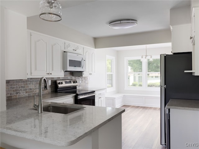1120 Temple St, Watertown-City, NY 13601 - kitchen with stainless steel appliances, white cabinets, light stone countertops, tasteful backsplash, and a peninsula