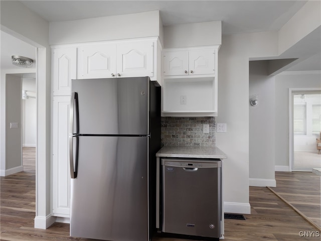 1120 Temple St, Watertown-City, NY 13601 - kitchen with appliances with stainless steel finishes, white cabinetry, dark wood-style floors, light countertops, and decorative backsplash