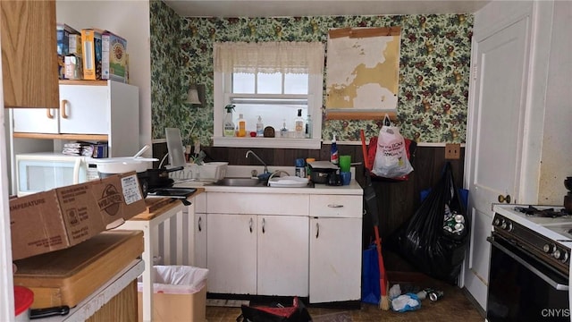216 Melrose Dr, Clay, NY 13212 - kitchen featuring range with gas stovetop, wallpapered walls, white cabinets, light countertops, and a sink