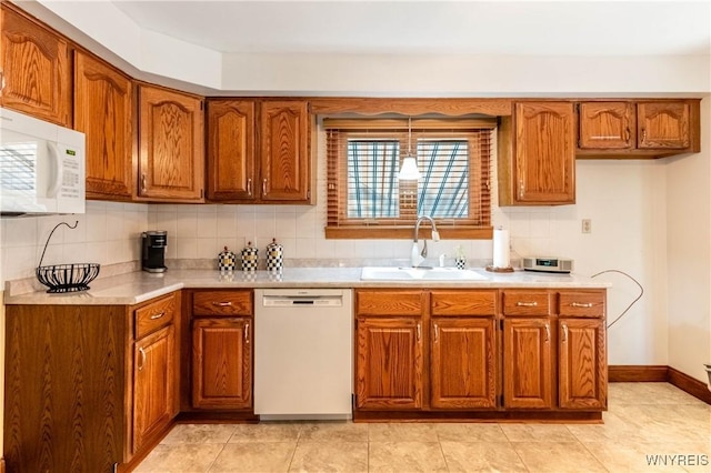 291 Everett Pl, Tonawanda-Town, NY 14150 - kitchen with white appliances, a sink, brown cabinetry, light countertops, and decorative backsplash