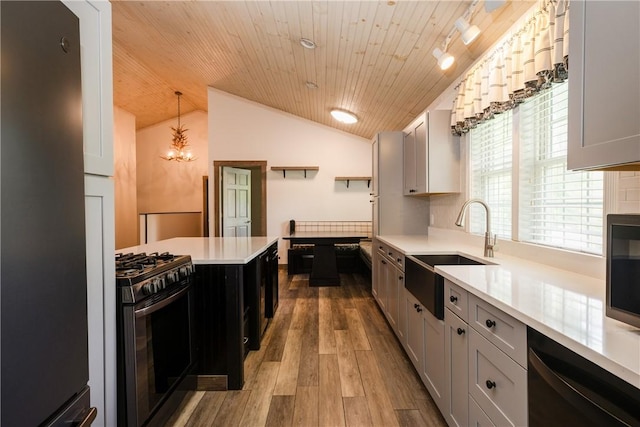 676 County Road 64, Big Flats, NY 14903 - kitchen with black appliances, light countertops, wood finished floors, vaulted ceiling, and a chandelier