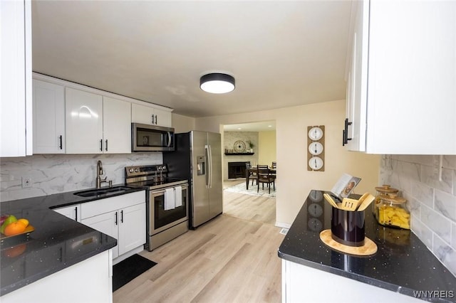 70 Minard St, Lockport-City, NY 14094 - kitchen with stainless steel appliances, a sink, white cabinets, and tasteful backsplash