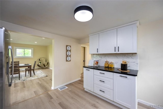 70 Minard St, Lockport-City, NY 14094 - kitchen with stainless steel fridge with ice dispenser, baseboards, tasteful backsplash, and white cabinetry