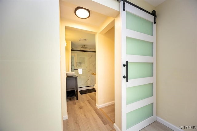 70 Minard St, Lockport-City, NY 14094 - hall with light wood-style flooring, a barn door, and baseboards