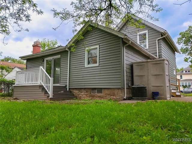 70 Minard St, Lockport-City, NY 14094 - rear view of house with a chimney and cooling unit