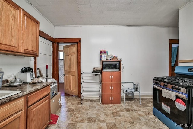 110 Saint Louis Ave, Buffalo, NY 14211 - kitchen with appliances with stainless steel finishes, brown cabinetry, dark countertops, stone finish flooring, and ornamental molding