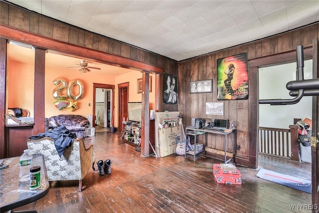 110 Saint Louis Ave, Buffalo, NY 14211 - living area featuring ornate columns, wood walls, wood-type flooring, and a ceiling fan
