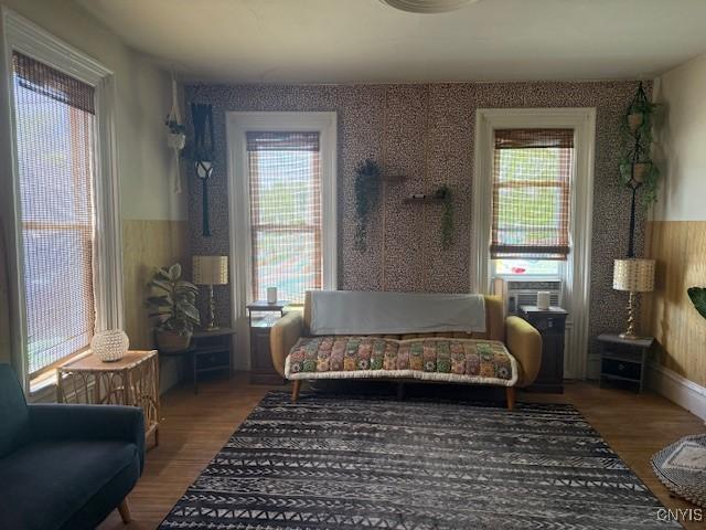 322 Eastern Ave, Herkimer, NY 13350 - sitting room featuring wood finished floors, healthy amount of natural light, cooling unit, and wallpapered walls