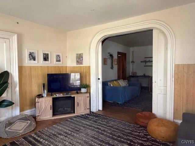322 Eastern Ave, Herkimer, NY 13350 - living room featuring arched walkways, a wainscoted wall, wood finished floors, and wood walls