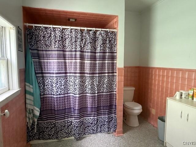 322 Eastern Ave, Herkimer, NY 13350 - full bath with toilet, a wainscoted wall, tile walls, and curtained shower