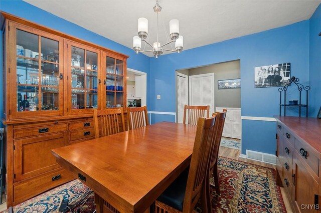 408 Elm St, Manlius, NY 13066 - dining room with a chandelier, light wood-style flooring, and baseboards