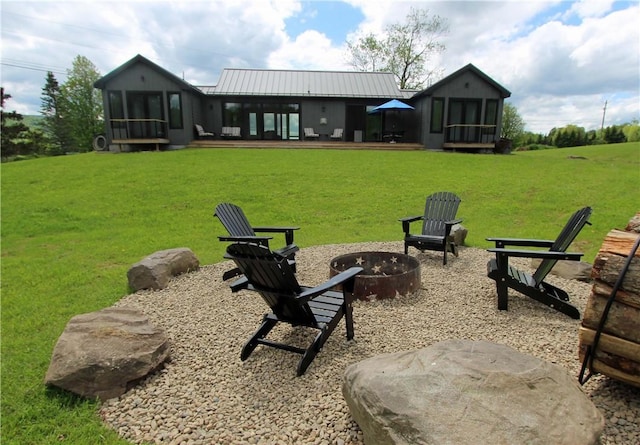 2185 Hog Mountain Rd, Middletown, NY 12455 - back of house with a sunroom, an outdoor fire pit, a yard, and metal roof