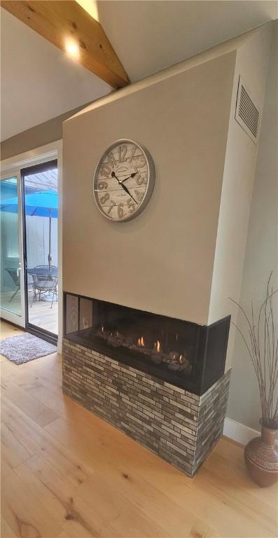 2185 Hog Mountain Rd, Middletown, NY 12455 - detailed view of wood finished floors, beamed ceiling, a multi sided fireplace, and baseboards