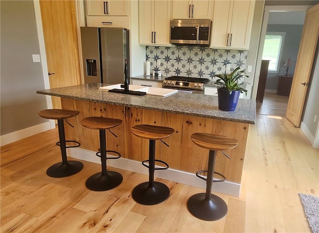 2185 Hog Mountain Rd, Middletown, NY 12455 - kitchen featuring stainless steel appliances, light wood finished floors, backsplash, dark stone countertops, and baseboards