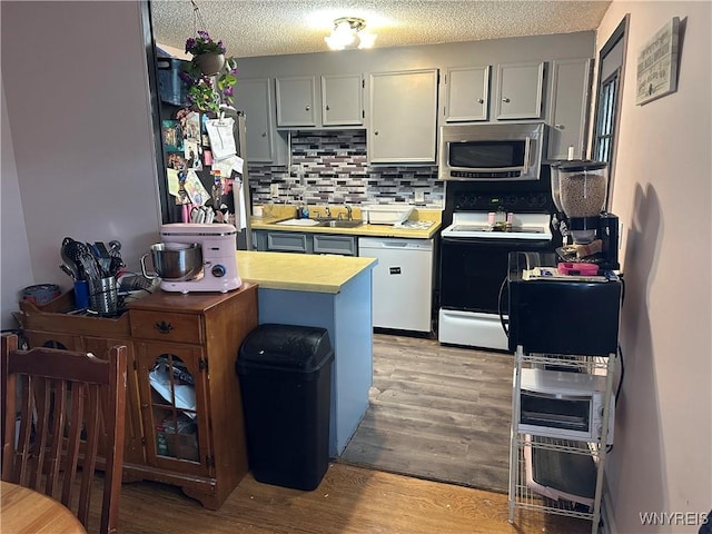 6954 Academy Ln, Lockport-Town, NY 14094 - kitchen with stainless steel microwave, electric range oven, light wood finished floors, light countertops, and backsplash