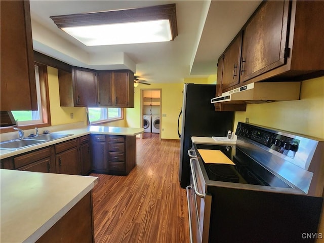 6 Heather Woods Ct, Skaneateles, NY 13152 - kitchen featuring black electric range, washing machine and clothes dryer, under cabinet range hood, a peninsula, and light countertops