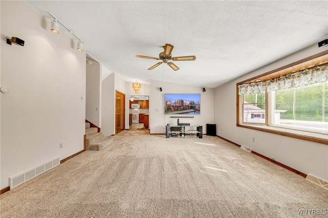 2350 Quaker Rd, Hartland, NY 14067 - carpeted living area with ceiling fan, baseboards, track lighting, stairway, and a textured ceiling