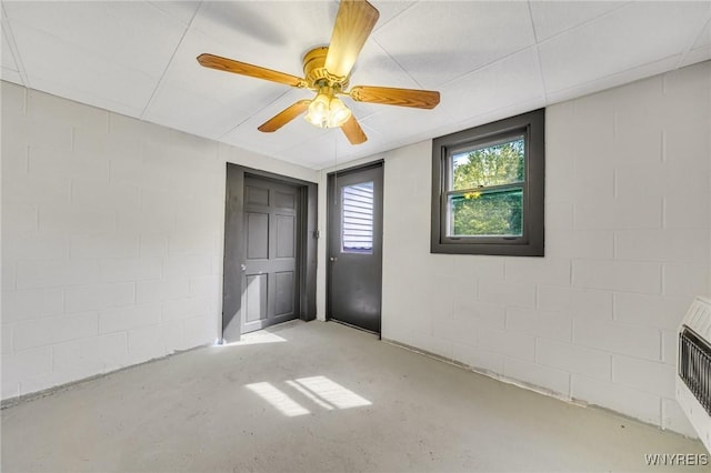 2350 Quaker Rd, Hartland, NY 14067 - unfurnished bedroom featuring concrete flooring, concrete block wall, and a ceiling fan