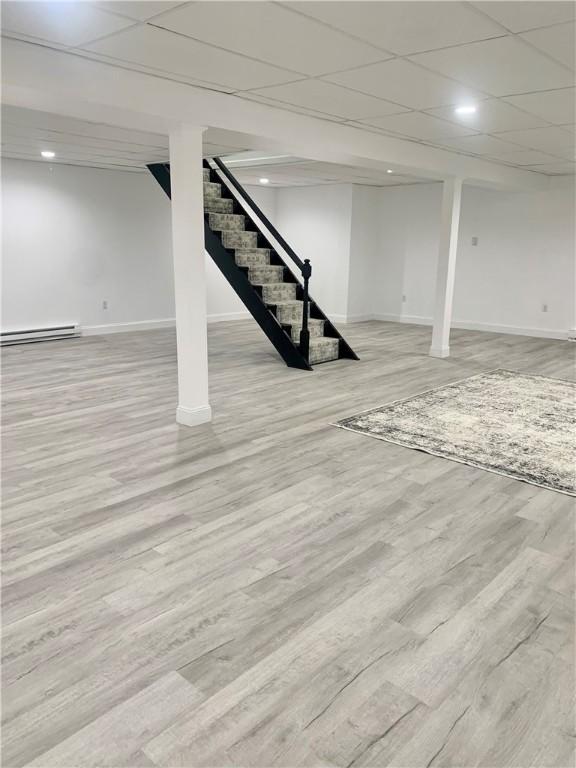 438 Hillview Ave, Southport, NY 14904 - finished basement featuring wood finished floors, baseboards, stairway, a baseboard radiator, and a paneled ceiling
