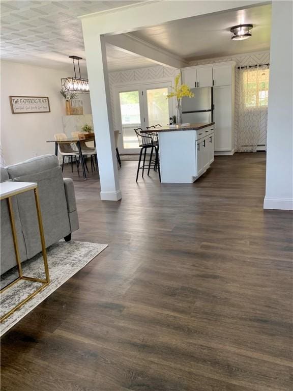 438 Hillview Ave, Southport, NY 14904 - kitchen with freestanding refrigerator, white cabinets, dark countertops, baseboards, and a breakfast bar