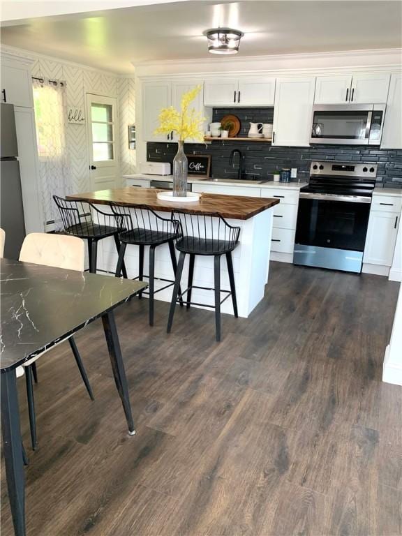 438 Hillview Ave, Southport, NY 14904 - kitchen with stainless steel appliances, wooden counters, white cabinetry, a sink, and dark wood-style flooring