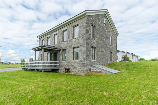 24401 Cheever Rd, Pamelia, NY 13601 - rear view of property with a yard, stone siding, cooling unit, and a deck