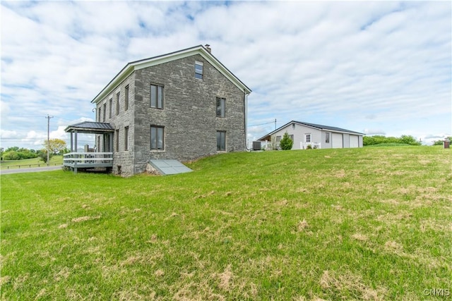 24401 Cheever Rd, Pamelia, NY 13601 - rear view of property featuring stone siding, a lawn, central AC, and a deck