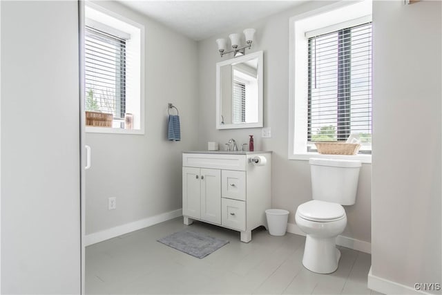 24401 Cheever Rd, Pamelia, NY 13601 - bathroom with healthy amount of natural light, toilet, vanity, and baseboards