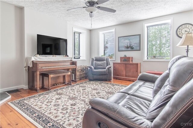24401 Cheever Rd, Pamelia, NY 13601 - living area featuring ceiling fan, wood finished floors, a textured ceiling, and baseboards