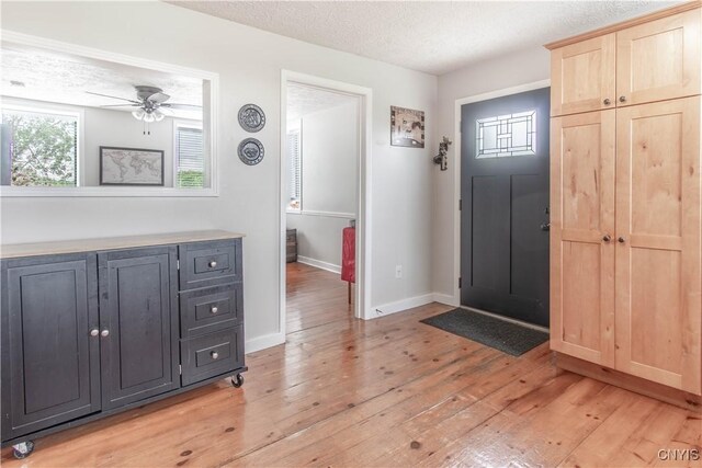 24401 Cheever Rd, Pamelia, NY 13601 - foyer with light wood finished floors, a ceiling fan, baseboards, and a textured ceiling