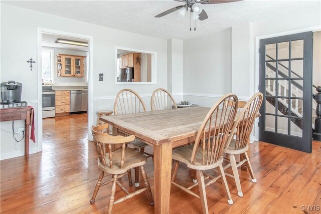 24401 Cheever Rd, Pamelia, NY 13601 - dining room featuring light wood-style flooring, a ceiling fan, a textured ceiling, and baseboards