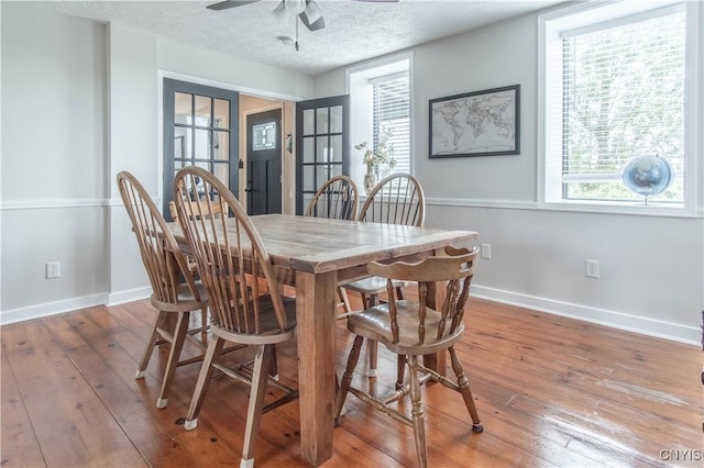 24401 Cheever Rd, Pamelia, NY 13601 - dining area featuring wood-type flooring, ceiling fan, baseboards, and a textured ceiling