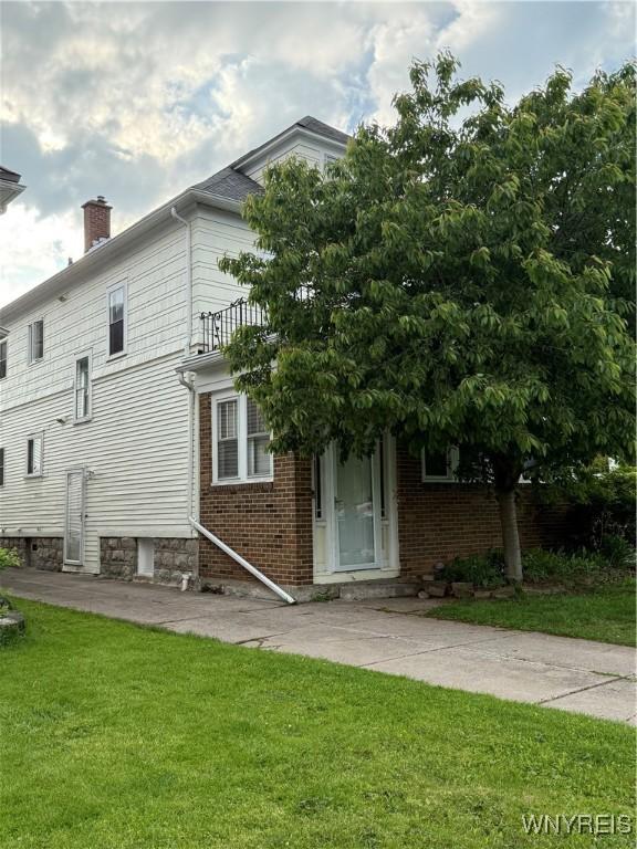 46 Cunard Rd, Buffalo, NY 14216 - back of house featuring a yard, a chimney, and brick siding